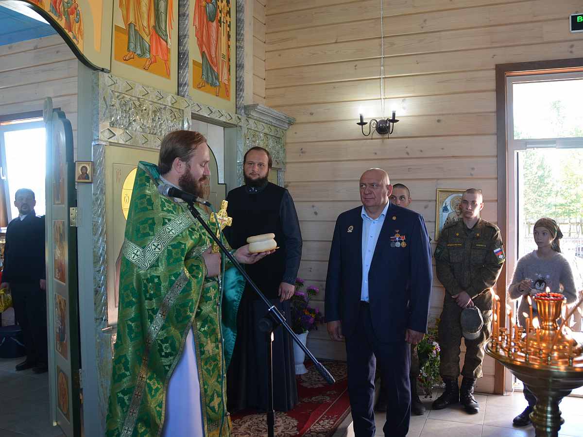Протоирей Иоанн вручает с благодарностью за служение основателю храма С. П. Костюкову почетную просвиру